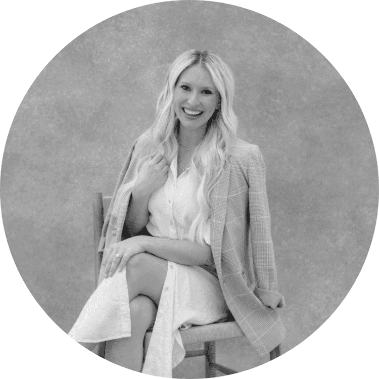 Lauren Fair seated in a chair, smiling, with long wavy blonde hair