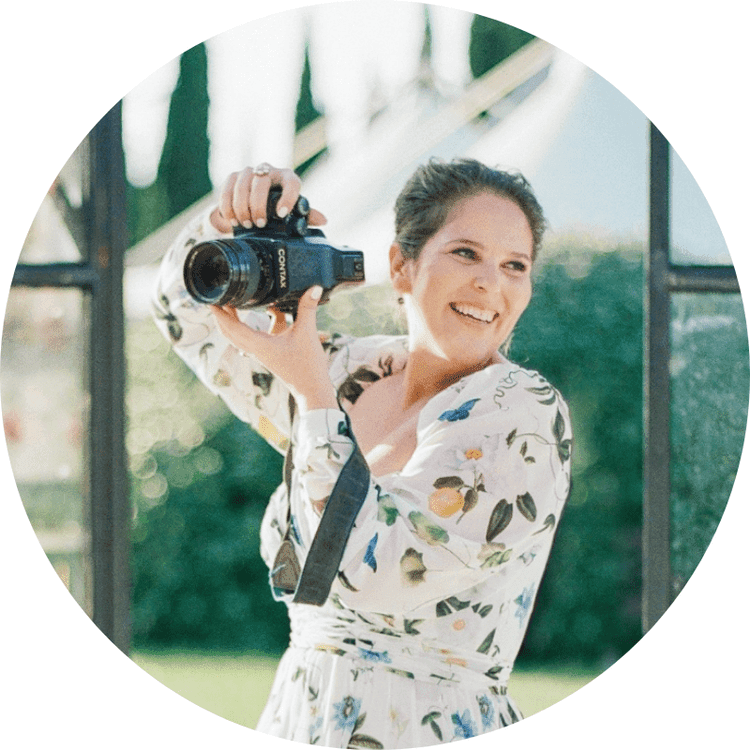 Rebecca Yale smiling outdoors, holding a camera up to her shoulder